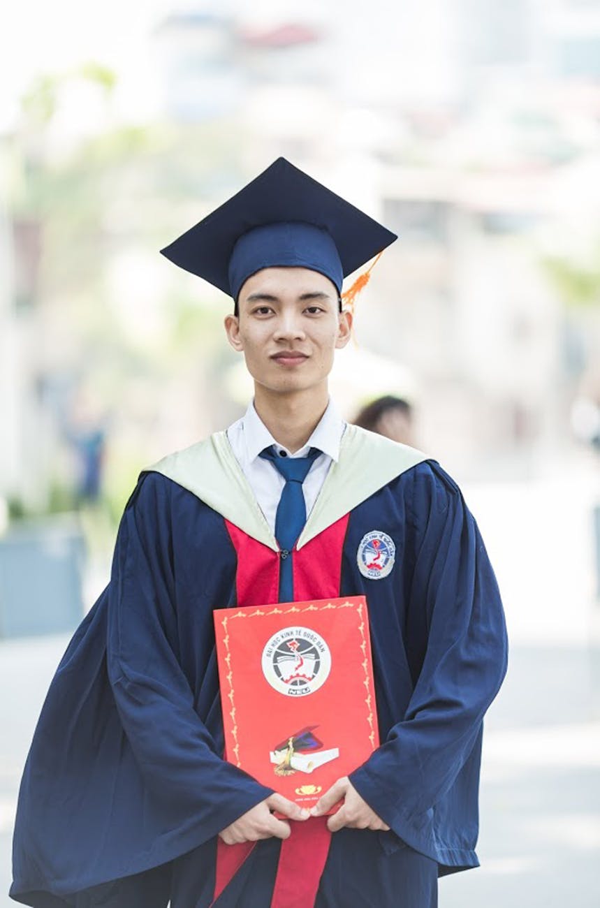 Study Abroad Proud graduate in academic gown holding diploma, celebrating academic success.